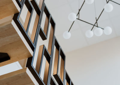 Escalier architectural pour espace entrée chez Ais Elec La Rochelle réalisé par Maya architecte d'intérieur Fouras